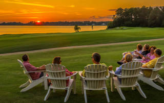 Members of the Two Rivers Country Club sitting in Adirondack lounge chairs overlooking the beautiful James River at Sunset.